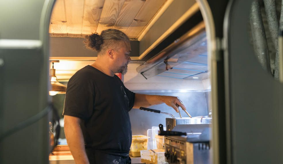 Franck, chef Eko Food & Co, prépare ses plats dans la food caravane